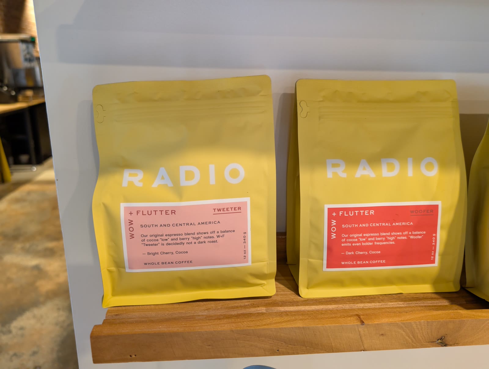 Yellow Radio Roasters coffee bags lined up on a wooden shelf