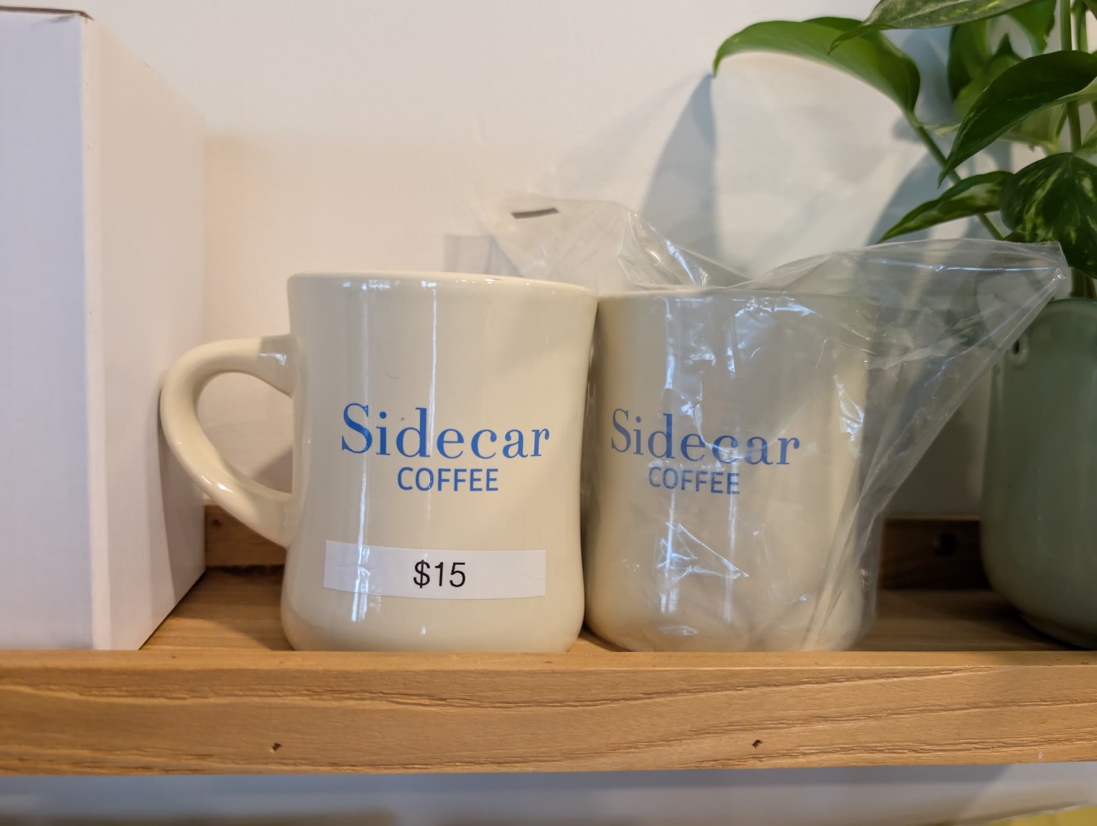 White Sidecar Coffee ceramic mugs on the merch shelf